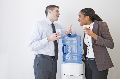 Business people talking together at water cooler